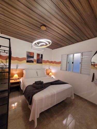 ein Schlafzimmer mit großem Bett und Holzdecke in der Unterkunft Studio com hidromassagem em Guararema in Guararema