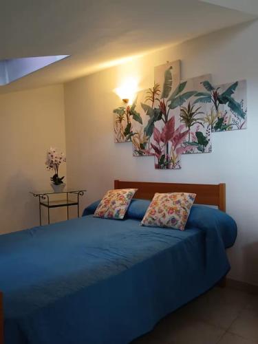 a bedroom with a blue bed with two pillows at Casa di Viaggiatori Ciampino in Ciampino