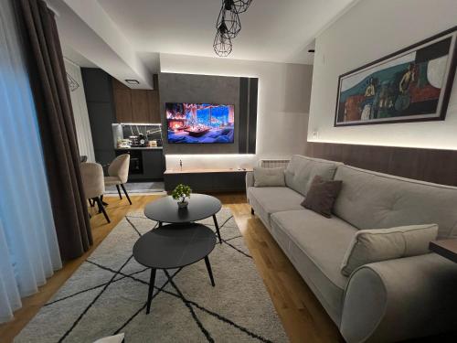a living room with a couch and a table at UrbanNest Aerodrom in Skopje