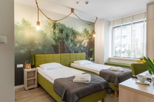 a bedroom with two beds and a painting on the wall at Aquapark Reda Resort - jedyne noclegi w Aquaparku Reda in Reda