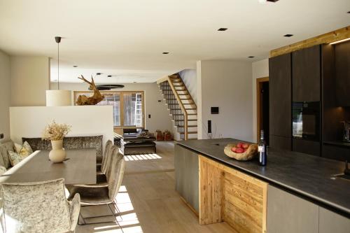 Una cocina y una sala de estar con mesa y sillas. en MALIA - Alpine Hideaway, en Pertisau