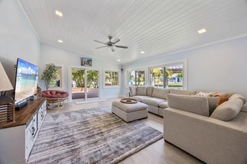 a living room with a couch and a tv at 4BR 2-5BA Waterfront Oasis w Pool and Dock in Cocoa Beach