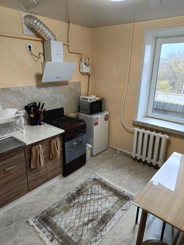 1 комнатные апартаменты في Pavlohrad: مطبخ صغير مع موقد ونافذة