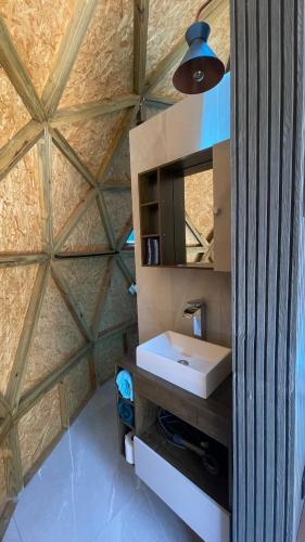 a bathroom with a sink and a wooden ceiling at Domo do Arquiteto in Igaratá