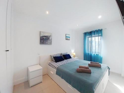 a white bedroom with a bed with blue sheets at Panorama Old Town sea view Albufeira in Albufeira