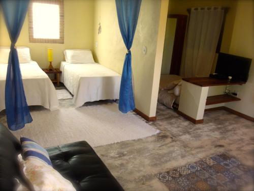 una sala de estar con dos camas y un sofá en Pousada do Sonho, en São Miguel dos Milagres