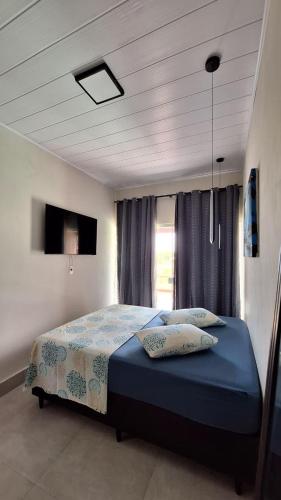 a bedroom with a bed with two pillows on it at Flat LITORAL SUL PB CARAPIBUS in Conde