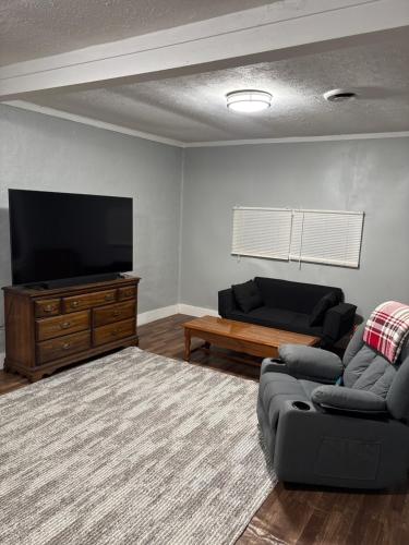 a living room with a couch and a flat screen tv at Cute Cottage in Maryville