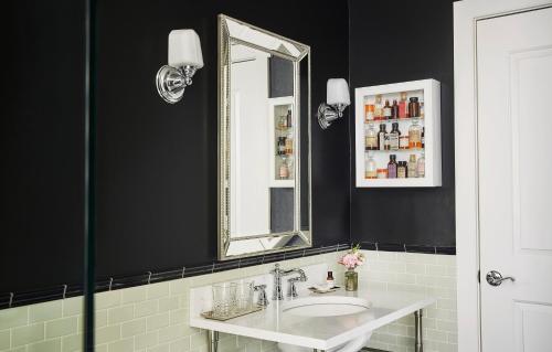
a bathroom with a mirror, sink, and toilet at Pontchartrain Hotel St. Charles Avenue in New Orleans
