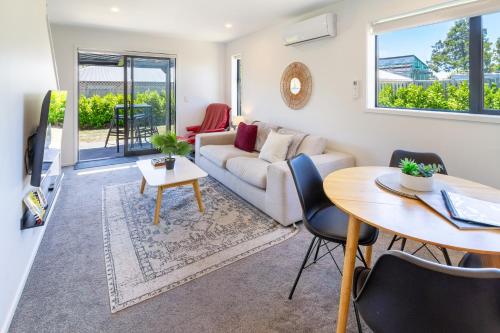 a living room with a couch and a table at Riccarton 2 bed 1 bath w/garage in Christchurch