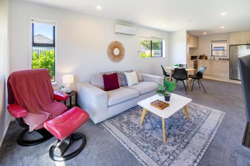 a living room with a couch and a table at Riccarton 2 bed 1 bath w/garage in Christchurch