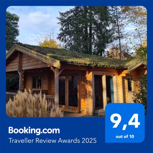 a house with a sign that says travel review awards at HderH - Eco Lodge op vakantiepark De IJsvogel, zwembaden, kids fun, natuur en rust in Voorthuizen