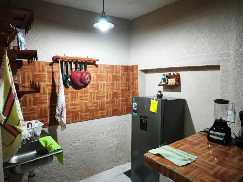 Una cocina con un refrigerador y una mesa dentro. en Adelita, en Atlixco