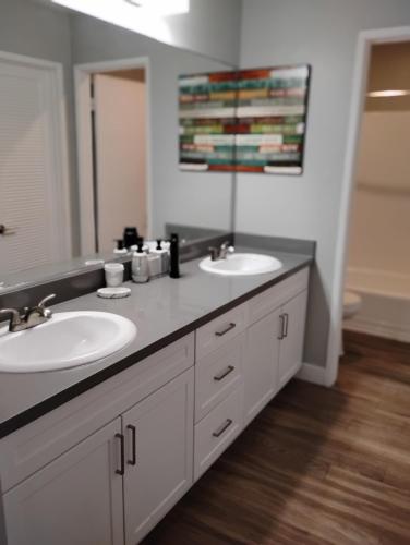 a bathroom with two sinks and a mirror at Cozy 2bdr Beach home in Huntington Beach