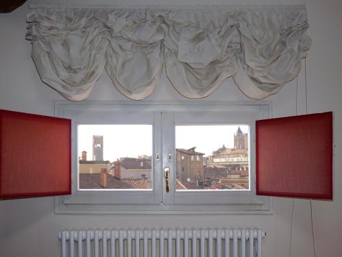 a window with a view of a city at Casa Isolani Charms Rooms Santo Stefano in Bologna