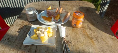 ein Tisch mit einem Teller mit Essen und einem Teller Obst in der Unterkunft Battambang Eco Stay &cooking class in Battambang