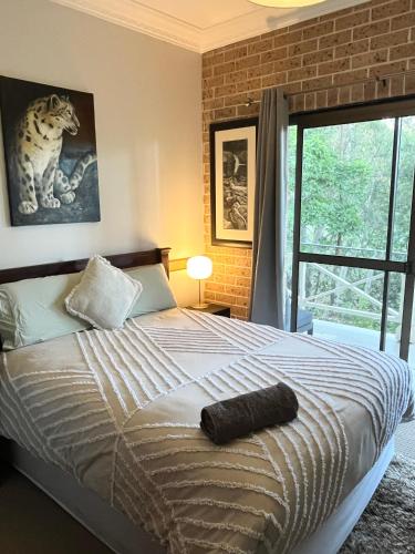 a bedroom with a bed and a large window at Mountain View Blue Mountains in Kurrajong
