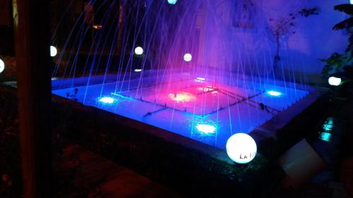 a room with purple and blue lights on a table at La Fontaine Apartments in Kandia