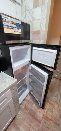 an empty refrigerator with its door open in a kitchen at The Cozy Corner in Canoga in Canoga Park