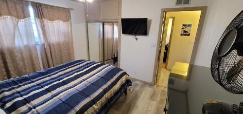 a bedroom with a blue and white bed and a television at The Cozy Corner in Canoga in Canoga Park