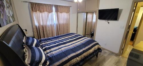 a bedroom with a bed and a flat screen tv at The Cozy Corner in Canoga in Canoga Park