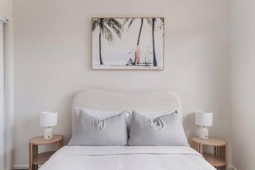 een slaapkamer met een wit bed met twee lampen bij Foreshore Escape - Beachside Comfort near Dining in Safety Beach