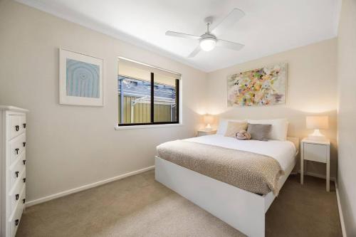 una camera da letto bianca con un letto e una finestra di Brighton Escape Seaside Living near Dining and Jetty a Brighton