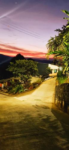 BuenavistaKira Apartahotel的一条土路,在后面有日落