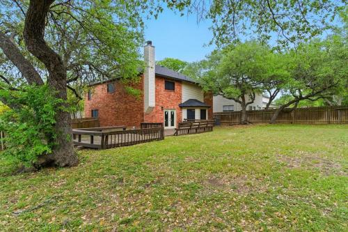 una casa con un árbol y una valla en Your Serene Escape in Schertz San Antonio and NB, en Schertz
