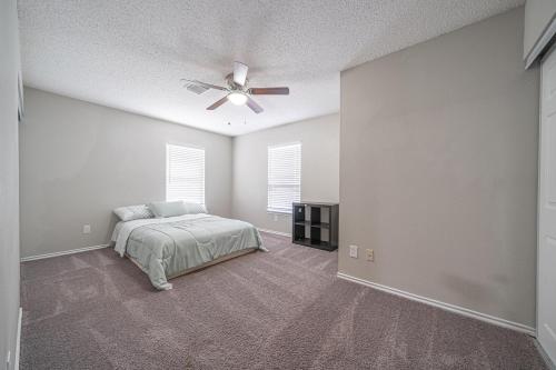 Un dormitorio con una cama y un ventilador de techo. en Your Serene Escape in Schertz San Antonio and NB, en Schertz