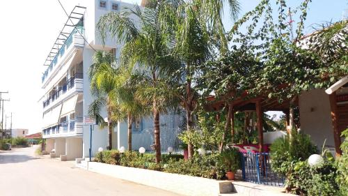 a building with palm trees next to a street at La Fontaine Apartments in Kandia