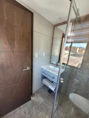 un bagno con lavandino e doccia di Refugio del Turista a Tupiza