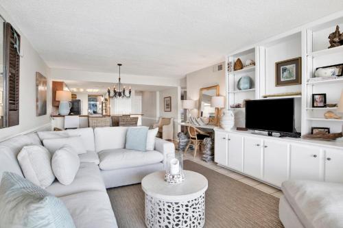 a living room with a white couch and a tv at Wind Drift 313N in Orange Beach