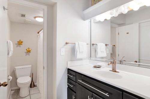 un bagno con lavandino, WC e specchio di Wind Drift 313N a Perdido Key