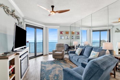 a living room with a blue couch and a tv at Phoenix East II 2154 in Orange Beach