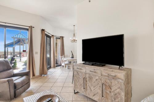 a living room with a flat screen tv on a wooden cabinet at Phoenix V 014 in Orange Beach