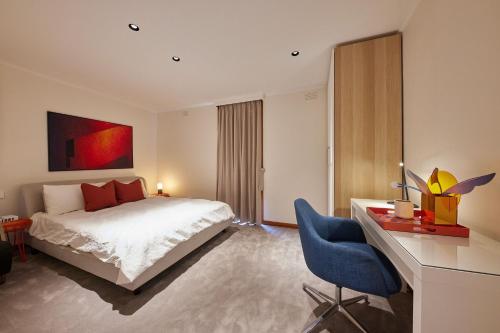 a bedroom with a bed and a desk with a chair at Stylish 2BR Family-Friendly Retreat 4Guests Doncaster Westfield in Doncaster