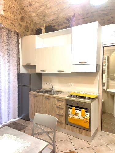 La Castellana في مونتي سانت أنجلو: مطبخ بخزائن بيضاء وفرن موقد