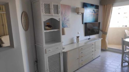 a living room with a white cabinet and a tv at Relax Beach in Benalmádena