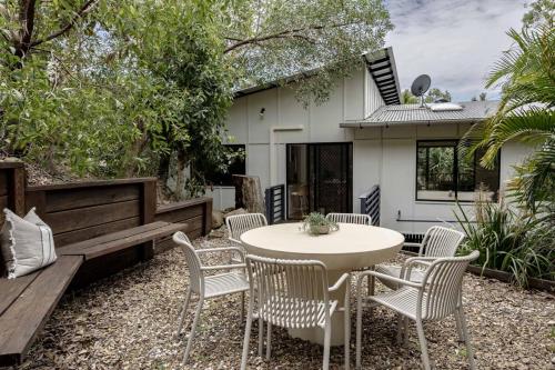 eine Terrasse mit einem Tisch und Stühlen sowie ein Haus in der Unterkunft Coastal Canopy - your doorstep to Mount Coolum in Coolum