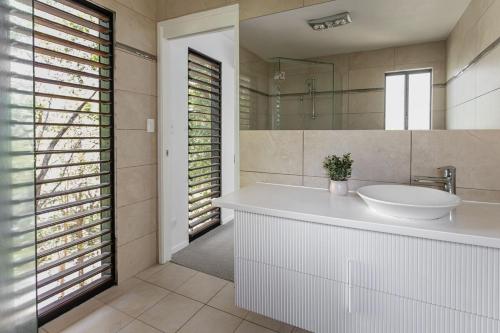 Coastal Canopy - your doorstep to Mount Coolum في كولوم: حمام مزود بحوض ومِرآة