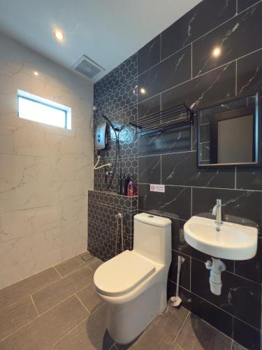 a bathroom with a white toilet and a sink at LYL 108 Private Pool Villa in Ipoh