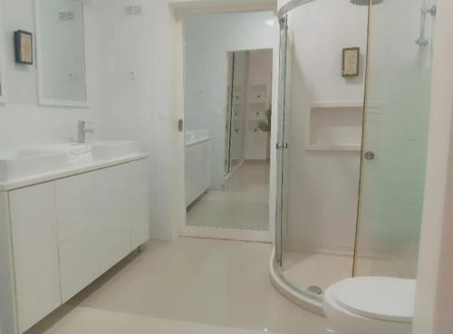 普拉亚Four Palms Boutique Hotel的带淋浴和卫生间的白色浴室