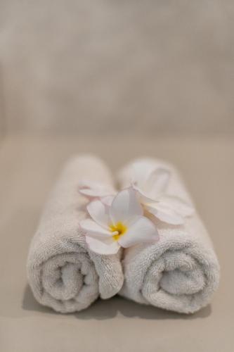 a towel with a flower on top of it at Pristine penida in Nusa Penida