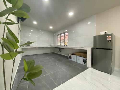 una cucina con frigorifero nero e pavimento piastrellato di Cozy Corner House, Bandar Utama a Gua Musang
