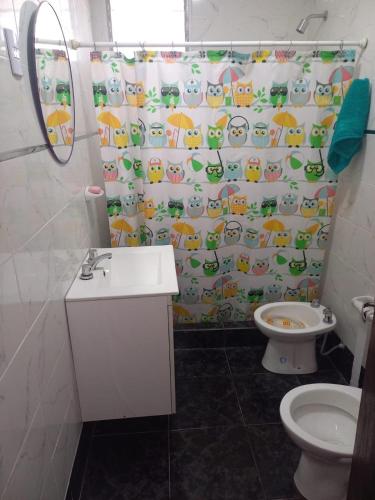 a bathroom with a toilet and a shower curtain at Descanso LA MARTA in Pueblo Esther