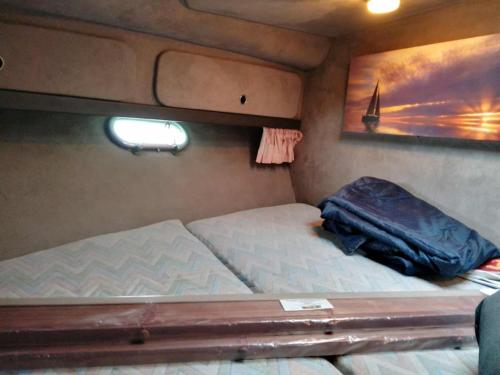 Sunseeker ZERO 6 - a Sunseeker San Remo 33 في Saint Peter Port: غرفة نوم صغيرة مع سريرين في مقطورة