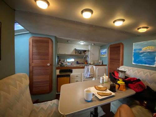 Sunseeker ZERO 6 - a Sunseeker San Remo 33 في Saint Peter Port: غرفة معيشة بها طاولة ومطبخ