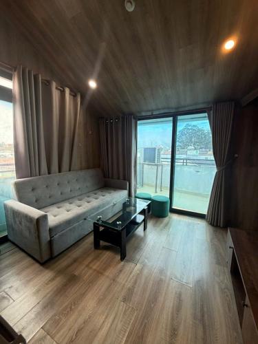a living room with a couch and a large window at Hotel Apartment Da Lat in Da Lat