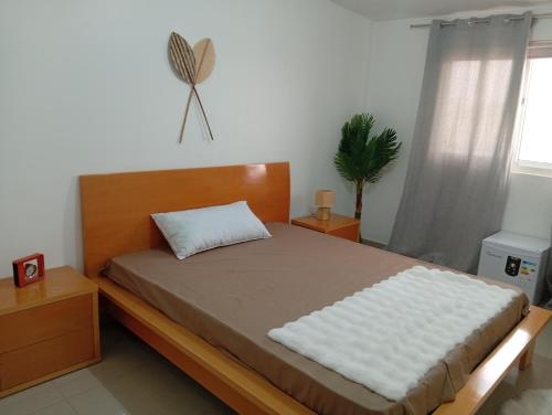 普拉亚Four Palms Boutique Hotel的卧室里有一张带木质床头板的床